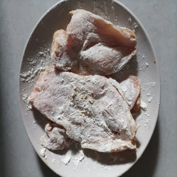 Taburi ayam yang sudah dimarinasi dengan tepung terigu hingga merata.