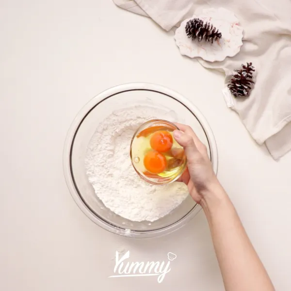 Tambahkan telur dan vanili, tuangkan susu secara bertahap sambil terus diaduk hingga tercampur rata dan tidak ada gumpalan.