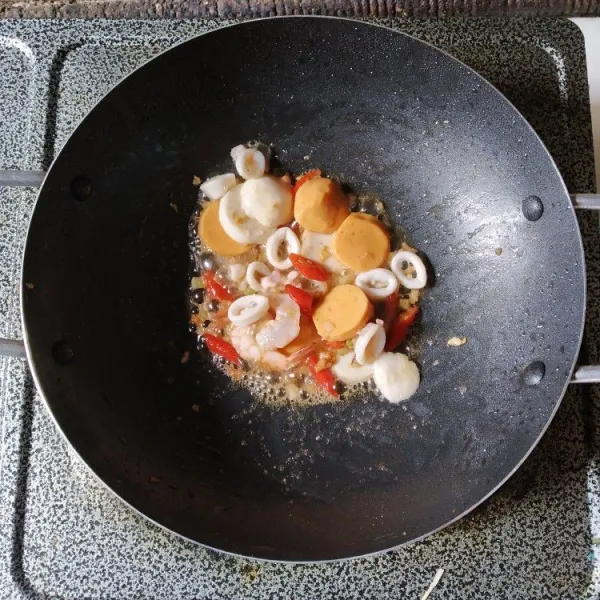 Masukkan udang, cumi, dan bakso, aduk hingga bumbu merata, masak hingga seafood berubah warna.