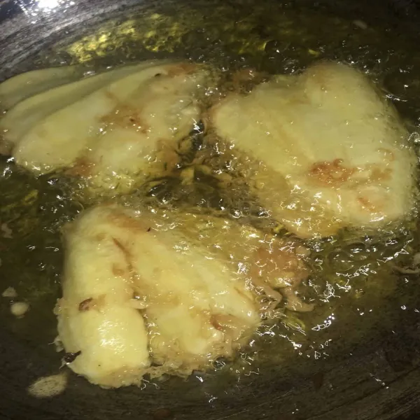 Lalu panaskan minyak goreng di wajan dan goreng pisang hingga matang keemasan, kemudian tiriskan dan sajikan.