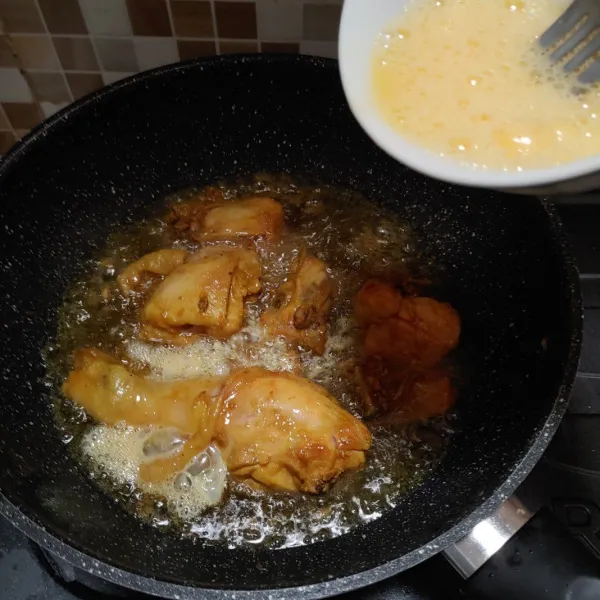 Panaskan minyak goreng, masukkan daging ayam yang sudah diungkep. Masak sebentar, kemudian siram dengan telur kocok dan biarkan hingga berubah warna kecoklatan. Angkat lalu tiriskan minyaknya dan sajikan.