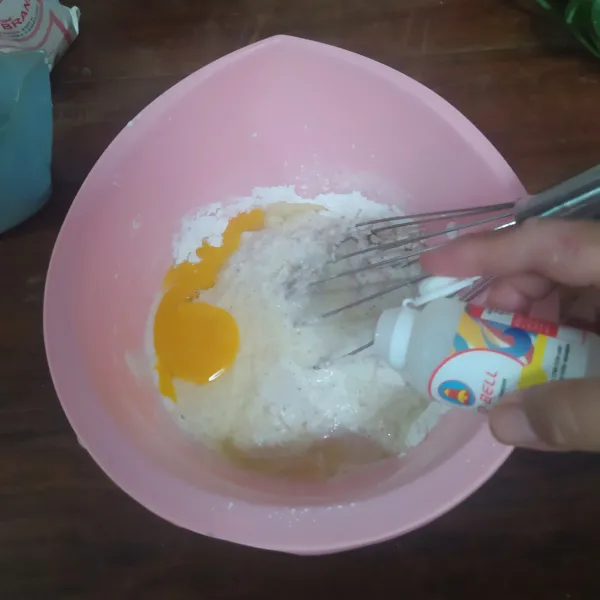 Masukkan telur, vanila essense, dan sisa santan. Kocok hingga gula larut.
