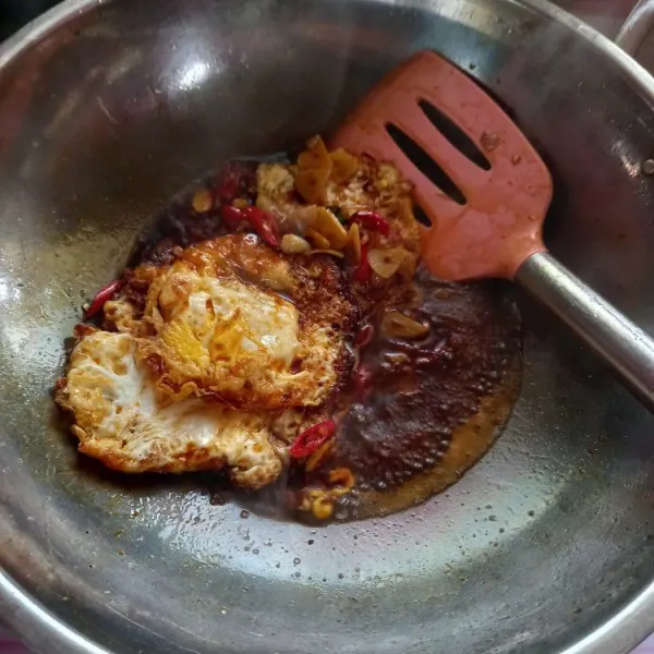 Masukkan telur ceplok, aduk merata sampai bumbu meresap, sajikan.