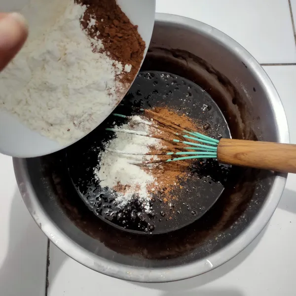 Masukkan tepung terigu dan coklat bubuk kemudian aduk rata kembali, setelah tepung masuk adonan akan semakin terasa berat dan kental.