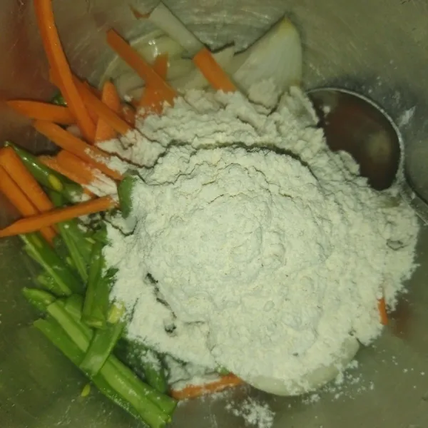 Siapkan wadah, masukkan sayuran yang sudah dipotong-potong, lalu masukkan tepung bakwan.