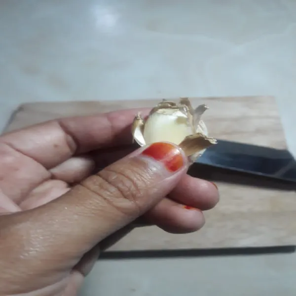 Lepaskan kulit bawang putih dengan menariknya dari buah bawang menggunakan tangan. Bawang putih siap digunakan.