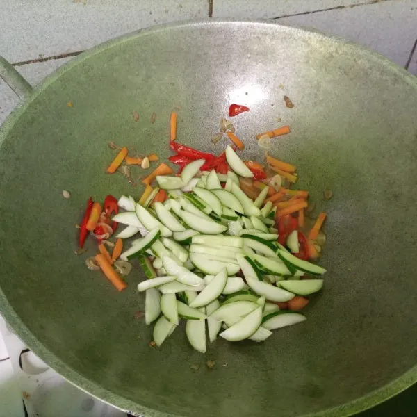 Masukkan irisan timun. Tambahkan tomat dan daun jeruk. Kemudian aduk-aduk sembari dicicipi rasanya. Masak sebentar hingga matang, lalu hidangkan.