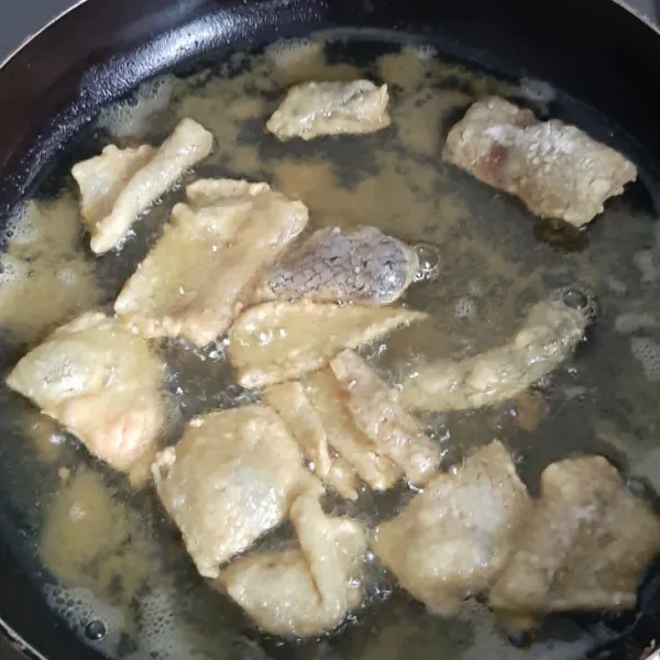 Panaskan wajan lalu goreng kulit ikan lalu sesekali dibalik sampai garing dan kecokelatan.