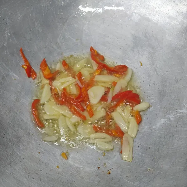 Tumis bawang putih dan cabai merah sampai layu dan harum.