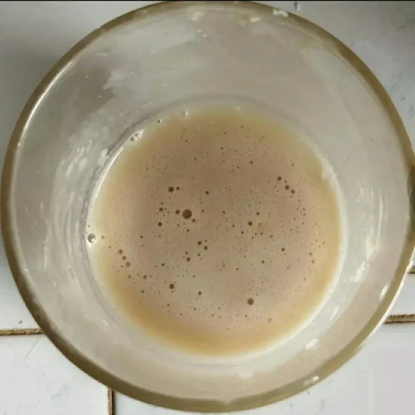 Buat biang ragi, campurkan air hangat, gula dan ragi. aduk rata, biarkan larutan berbusa tanda bahwa ragi masih aktif.