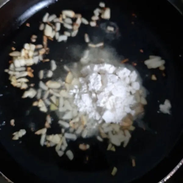 Setelah bawang wangi dan kecokelatan lalu masukkan jamur yang sudah diiris lalu aduk  beri tepung, aduk lagi.