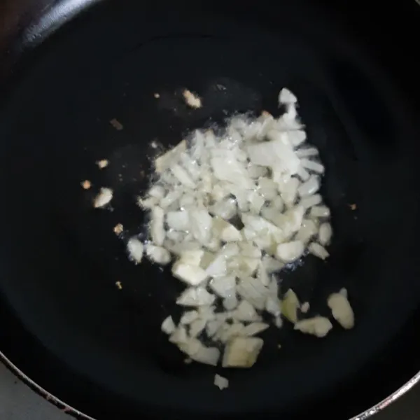 Panaskan wajan lalu goreng bawamg bombay dan bawang putih yang sudah diiris.
