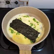 Panaskan margarin, tuang adonan telur tipis-tipis merata pada wajan. Lalu tambahkan nori, jika bagian bawah sudah matang, gulung telur, kemudian sisihkan ke pinggir wajan.