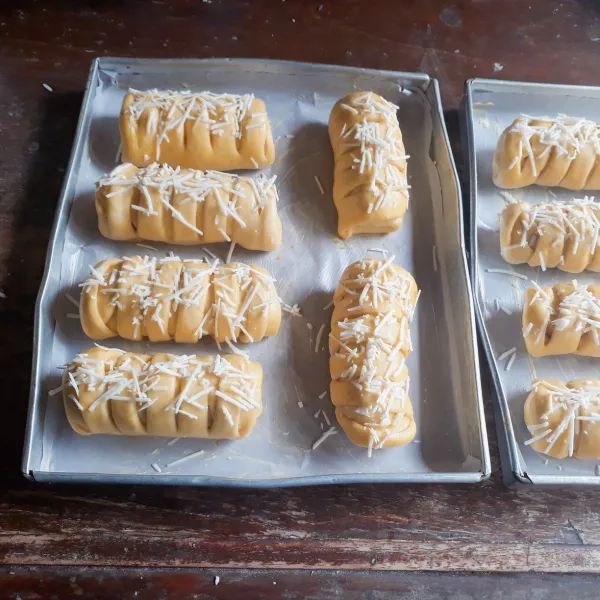 Tata dalam loyang yang sudah diolesi margarin, diamkan 15 menit, olesi dengan bahan olesan dan taburi keju parut.