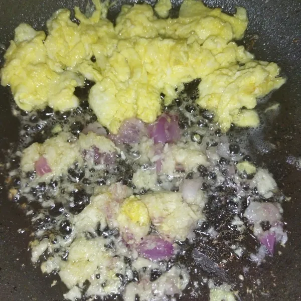 Lalu panaskan kembali minyak goreng secukupnya, lalu goreng telur, lalu buat orak-arik, lalu masukkan bawang merah dan bawang putih yang sudah diparut, tumis hingga harum.