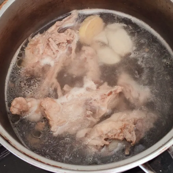 Masukan air, tulang ayam, bawang putih dan jahe ke pan. Rebus 20-30 menit dengan api kecil hingga kaldu tulang ayam keluar.