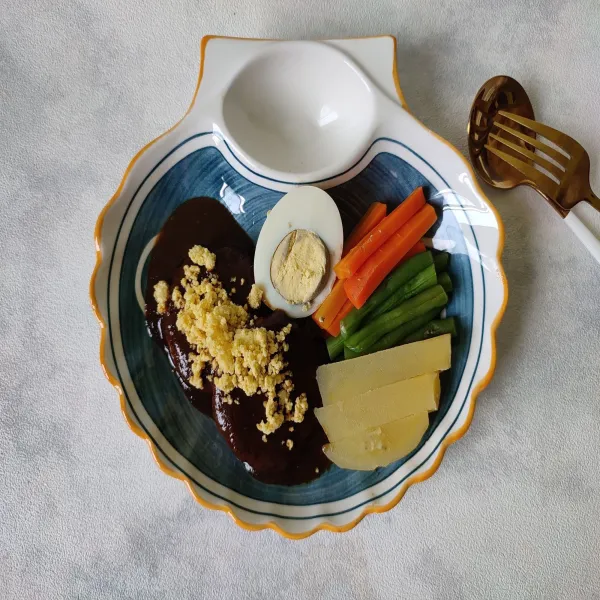Sajikan selat vegan dengan sayuran rebus, telur, serta saos selat di atas piring saji.