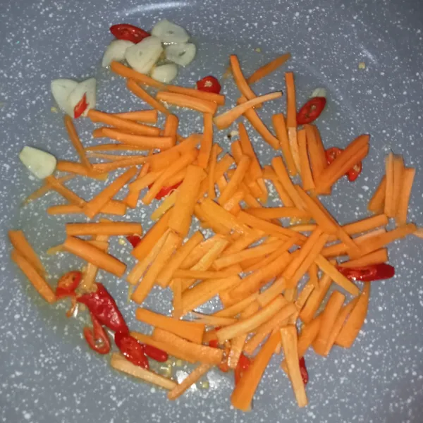 Panaskan minyak, kemudian masukkan bawang dan cabai merah, aduk rata. Kemudian masukkan wortel kembali hingga merata.