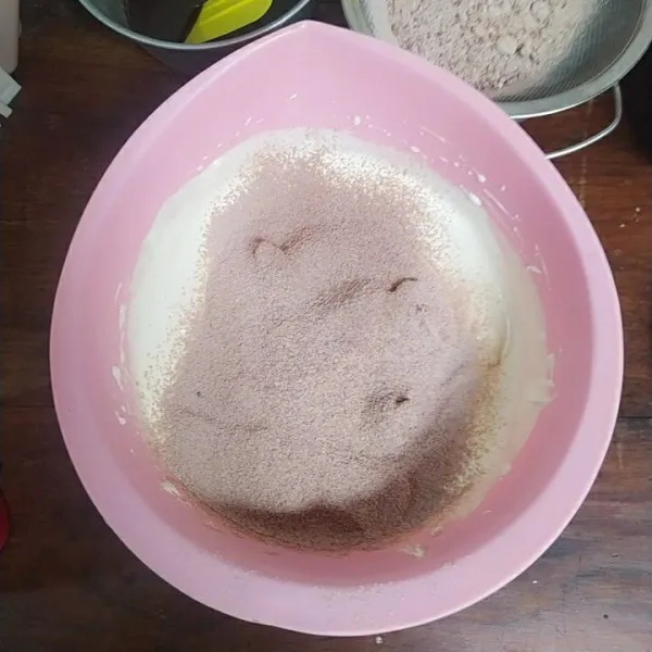 Masukkan campuran tepung dengan cara diayak sambil diaduk dengan teknik aduk balik.