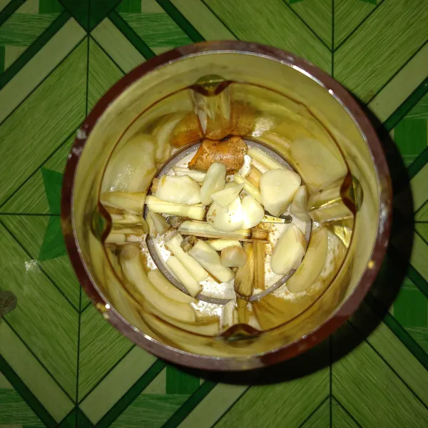 Iris bawang putih, serai, jahe, dan kunyit. Lalu masukkan ketumbar bubuk.