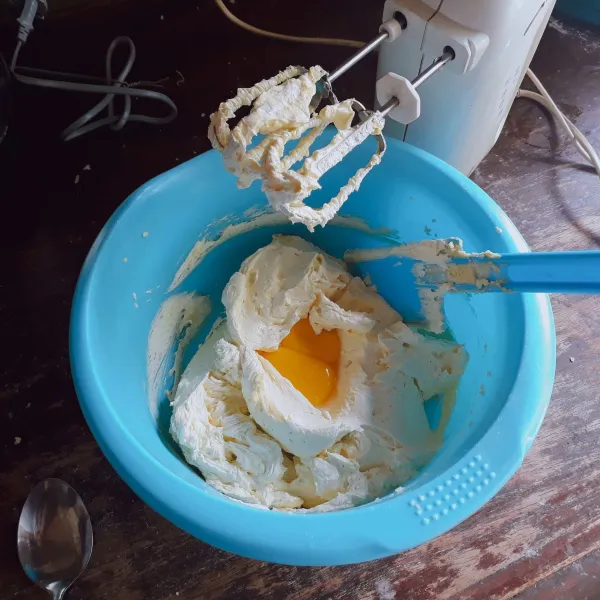 Mixer gula dan margarin dengan kecepatan tinggi selama 2 menit. Masukkan kuning telur, mixer asal rata saja.