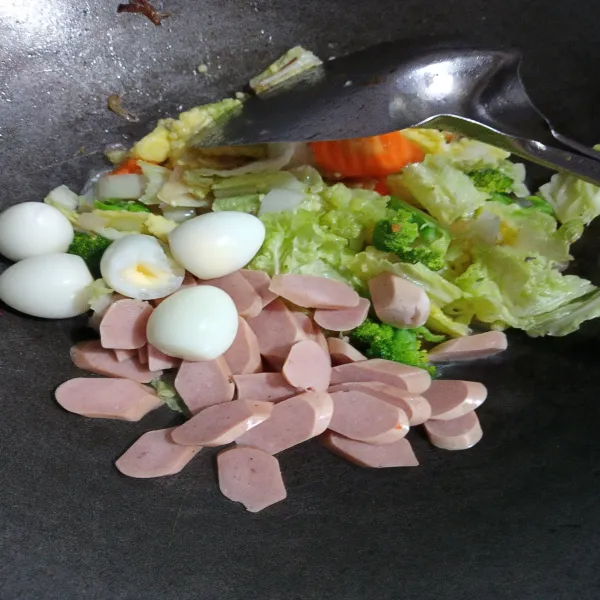 Masukkan sosis dan telur puyuh. Aduk-aduk lagi hingga tercampur rata. Jika sudah matang angkat.