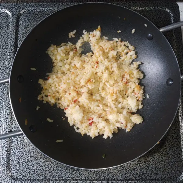 Masukkan nasi putih, bumbui dengan kaldu bubuk, garam, dan penyedap, aduk hingga bumbu rata.