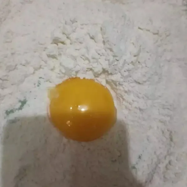Campur tepung terigu, susu bubuk, dan baking powder, buat bulatan di tengah, masukkan telur. Aduk rata, beri bahan biang. Uleni setengah kalis.