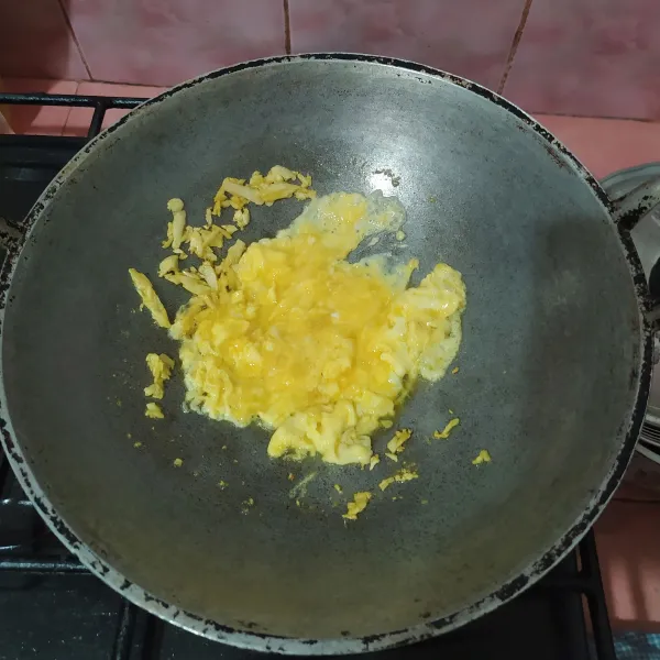 Sisihkan bawang putih di pinggir wajan, lalu masukkan kocokan telur, buat orak-arik.