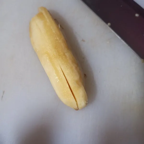 Kupas pisang lalu potong memanjang menjadi 4 bagian