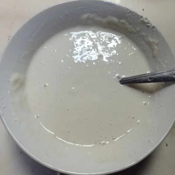 Lalu masukkan susu cair dan vanila essence, aduk sampai mendapati adonan kental dan tidak bergerindil.