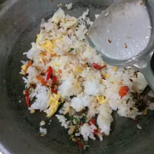 Tambahkan nasi, beri garam, kaldu bubuk, ladabubuk, dan gula pasir, lalu aduk hingga rata dan matang.