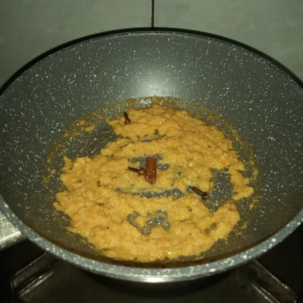 Panaskan wajan, tumis bumbu halus tanpa minyak sampai cairan bumbu habis. Kemudian tambahkan kayu manis dan cengkeh, lalu aduk-aduk.
