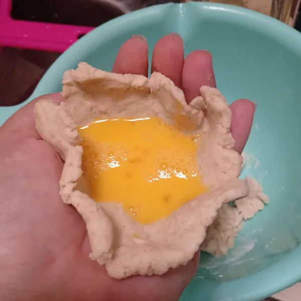 Ambil adonan lalu bentuk seperti mangkuk, isi dengan telur kocok, rekatkan.