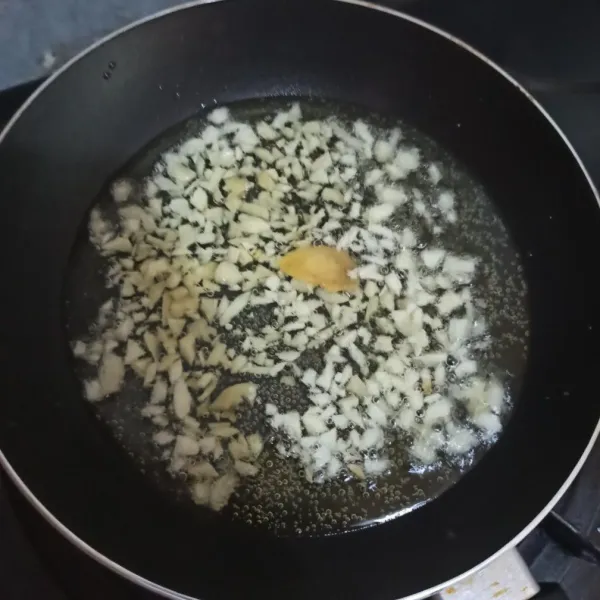 Masukkan bawang putih yang sudah di rajang dan jahe iris.