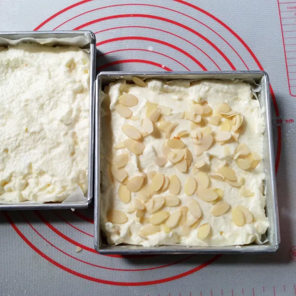 Tuang adonan ke 2 buah loyang yang sudah di olesi dengan margarin dan di alasi baking paper. Taburi salah satu loyang dengan almond slice.