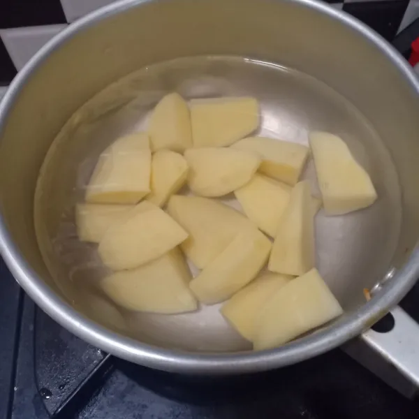 Potong-potong kentang kotak-kotak. Rebus kentang selama 20 menit lalu tiriskan sampai dingin.