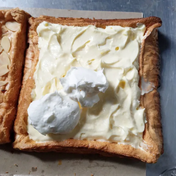 Di pastry yang tidak ada almondnya beri cream lemon, lalu ratakan. Timpa dengan cream original, lalu ratakan.