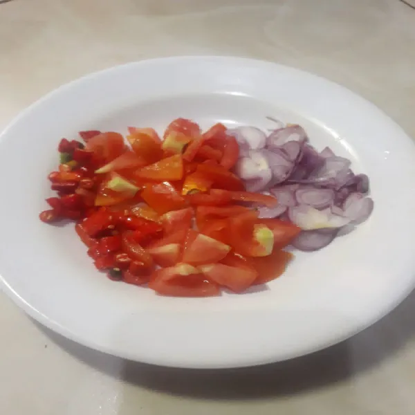 Potong-potong tomat, cabai, dan bawang merah.