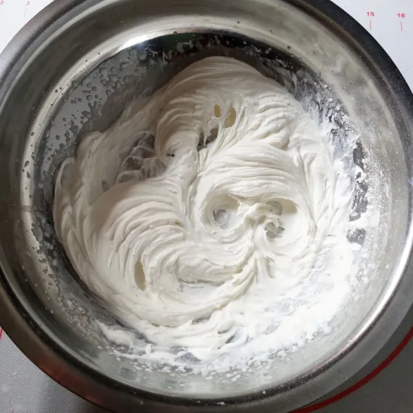 Buat Filling : kocok bubuk whipped cream dan air es sampai kaku, kemudian bagi 2.