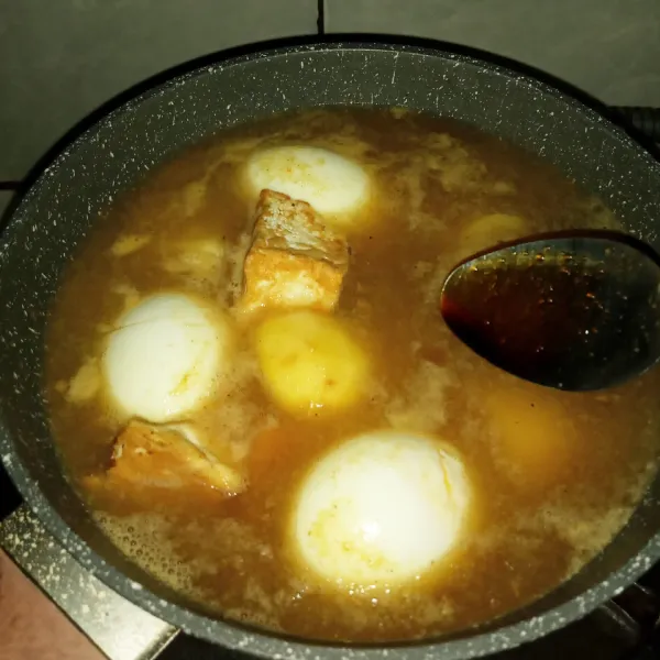 Setelah mendidih masukkan telur, tahu, dan kentang. Bumbui dengan kecap manis, masak sampai kentang empuk.