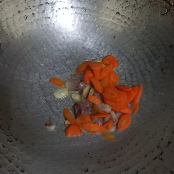 Masukkan irisan wortel, lalu aduk rata. Masak hingga wortel setengah matang.