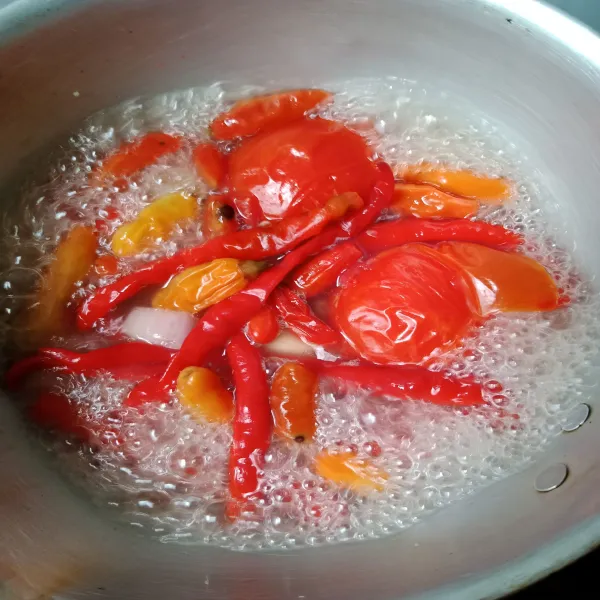 Rebus cabe, bawang putih, bawang merah, dan tomat. Kemudian haluskan.