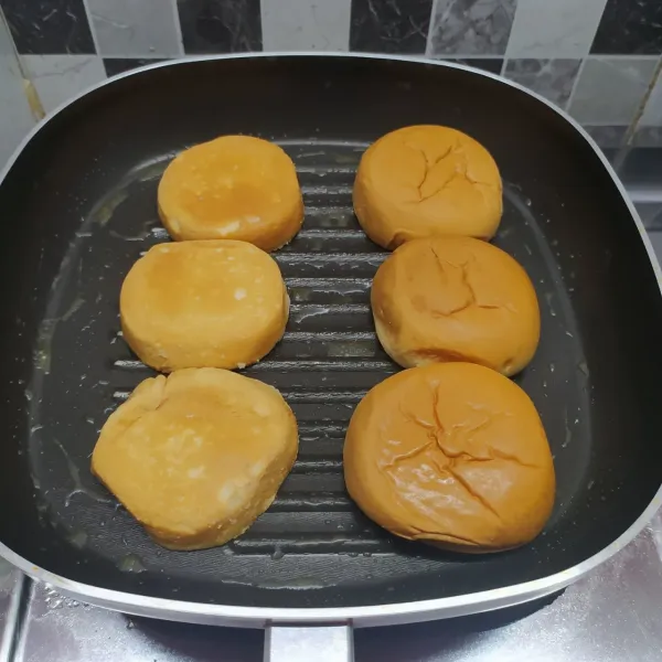 Oles grill pan dengan margarin, panggang roti burger di kedua sisi bolak balik. Angkat sisihkan.