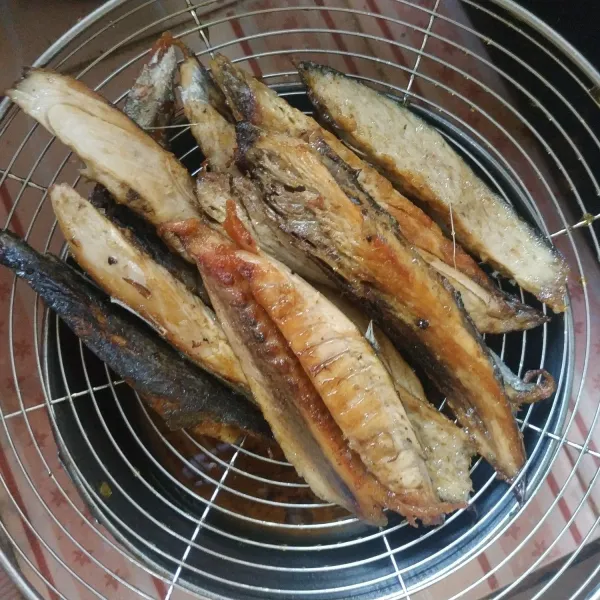 Cuci bersih ikan tongkol yang sudah dipotong-potong, kemudian goreng hingga setengah matang.