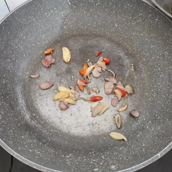 Tumis bawang merah dan bawang putih sampai sedikit layu, baru tambahkan cabai dan aduk merata.
