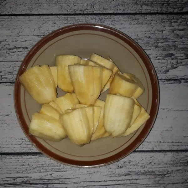 Kupas pisang, potong 2 bagian lalu belah tanpa putus dan bentuk seperti kipas.