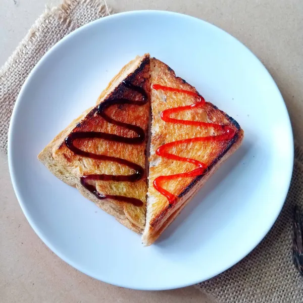 Potong jadi 2 bagian. Beri topping selai strawberry dan blueberry agar lebih cantik.