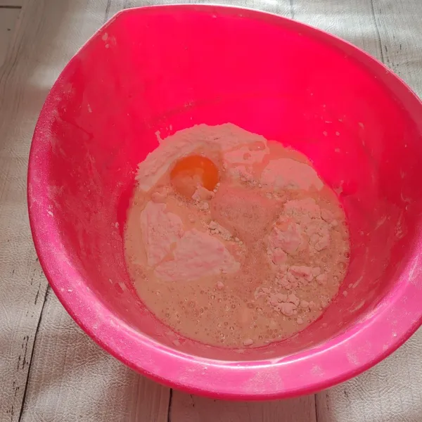 Masukkan gula pasir dan ragi ke dalam gelas, lalu tambahkan air hangat dan biarkan sampai ragi berbusa. Tuang campuran ragi dan air ke dalam tepung, tambahkan kuning telur, lalu uleni hingga setengah kalis.