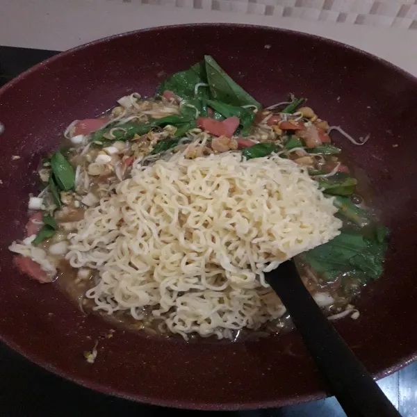 Masukkan mie yang sudah direbus.
Aduk sampai bumbu tercampur rata.